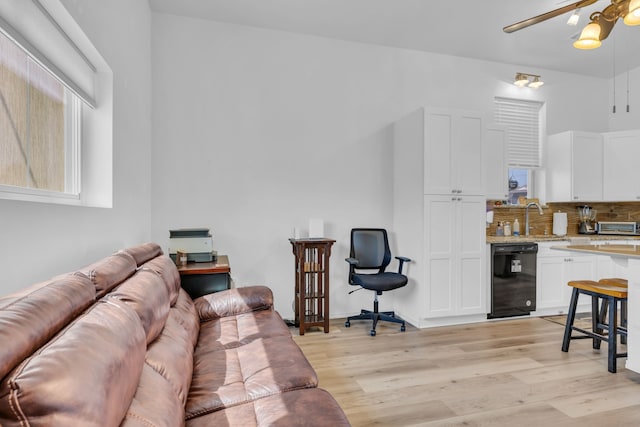 living room featuring a toaster, light wood finished floors, and a ceiling fan
