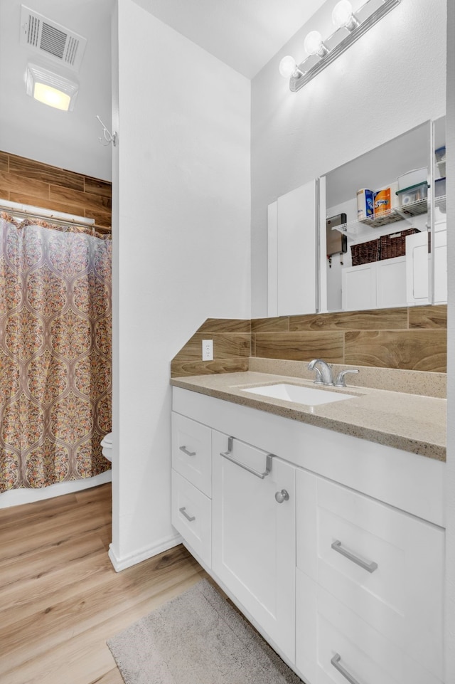 full bath featuring vanity, visible vents, toilet, curtained shower, and wood finished floors