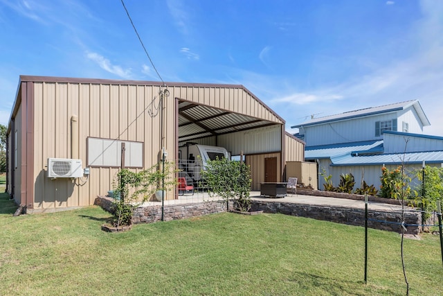 rear view of property with a yard, a patio, and an outbuilding