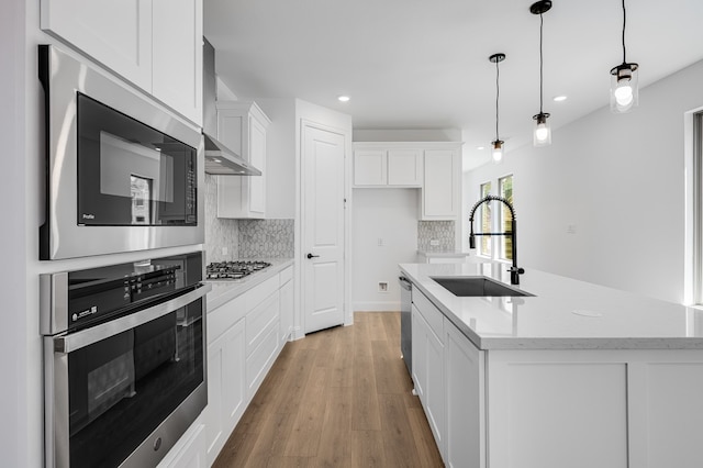 1538 Ginger Ln, Argyle, TX 76226 - kitchen with stainless steel appliances, a sink, wall chimney exhaust hood, white cabinets, and decorative backsplash