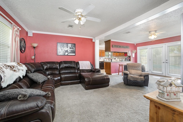 1128 Mason Dr, Hurst, TX 76053 - living area with ornamental molding, light carpet, a textured ceiling, a ceiling fan, and visible vents