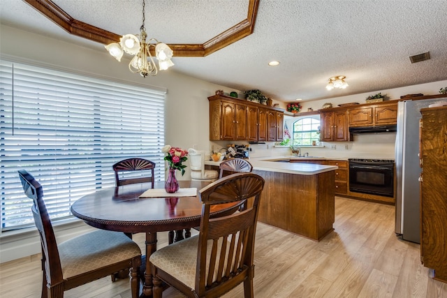 9A Rhea Mills Cir, Prosper, TX 75078 - kitchen featuring under cabinet range hood, freestanding refrigerator, stove, a textured ceiling, and a chandelier