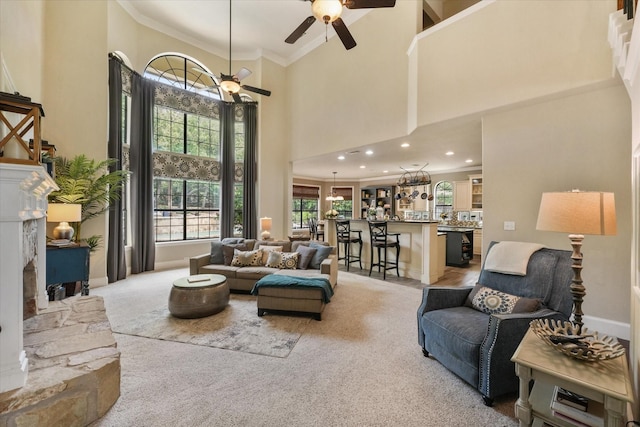 3604 Post Oak Trl, Corinth, TX 76210 - living room with ceiling fan, light colored carpet, ornamental molding, a towering ceiling, and a fireplace with raised hearth