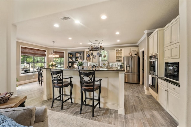 3604 Post Oak Trl, Corinth, TX 76210 - kitchen with stainless steel appliances, dark countertops, a chandelier, a kitchen bar, and ornamental molding
