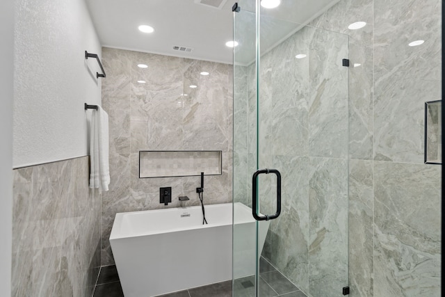 bathroom with recessed lighting, tile walls, a shower stall, visible vents, and a soaking tub