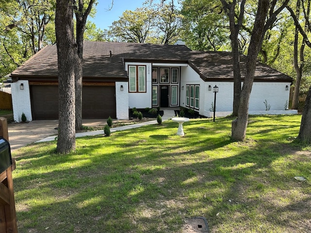 view of front facade featuring a front lawn, a garage, concrete driveway, and brick siding