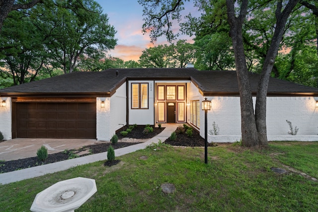 view of front of home featuring a garage, brick siding, and driveway