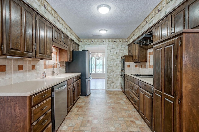 6809 River Bend Rd, Fort Worth, TX 76132 - kitchen featuring a textured ceiling, tasteful backsplash, a sink, light countertops, and stainless steel appliances