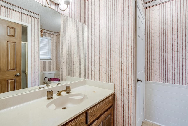 6809 River Bend Rd, Fort Worth, TX 76132 - bathroom with vanity, wainscoting, wallpapered walls, and a textured ceiling