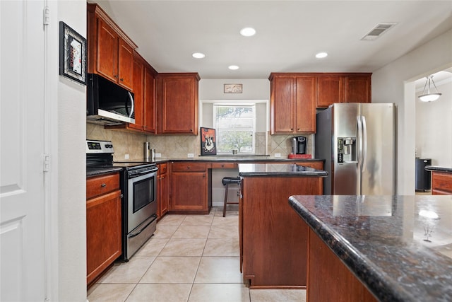 10908 County Road 442, Princeton, TX 75407 - kitchen with light tile patterned floors, a center island, visible vents, decorative backsplash, and stainless steel appliances
