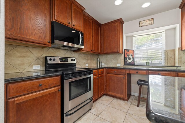 10908 County Road 442, Princeton, TX 75407 - kitchen featuring dark stone counters, light tile patterned floors, recessed lighting, stainless steel appliances, and backsplash