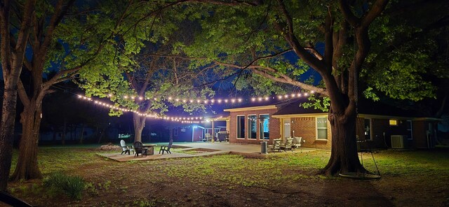 10908 County Road 442, Princeton, TX 75407 - yard at night featuring a patio area