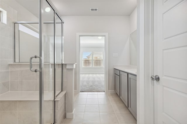 full bathroom with tile patterned flooring, a stall shower, and vanity