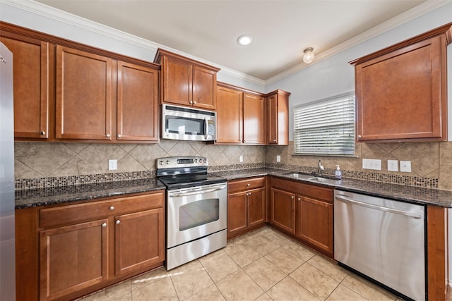 kitchen featuring light tile patterned floors, brown cabinetry, a sink, stainless steel appliances, and decorative backsplash