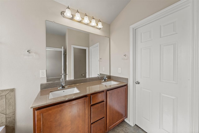 full bathroom with a shower with door, double vanity, and a sink