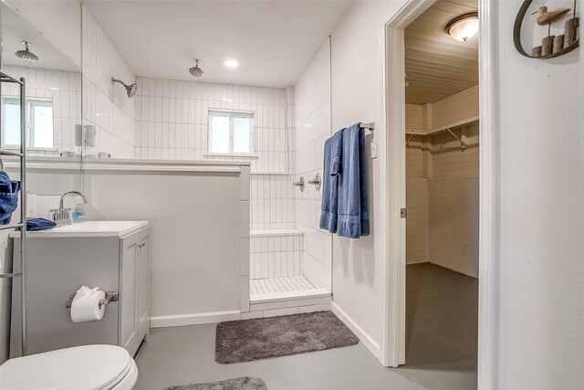 2520 Long Creek Ct, Granbury, TX 76049 - bathroom featuring vanity, toilet, tiled shower, a walk in closet, and concrete flooring