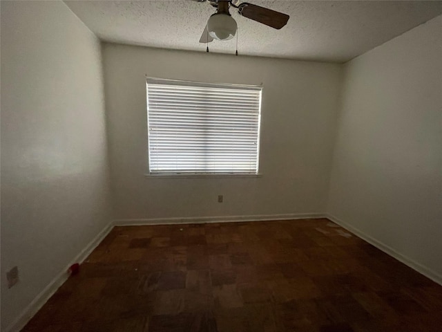 empty room featuring baseboards, a textured ceiling, and ceiling fan