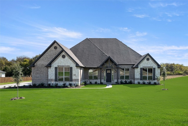 rear view of property with roof with shingles, brick siding, stone siding, and a lawn