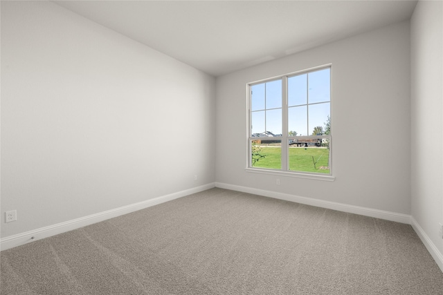 unfurnished room with carpet flooring and baseboards