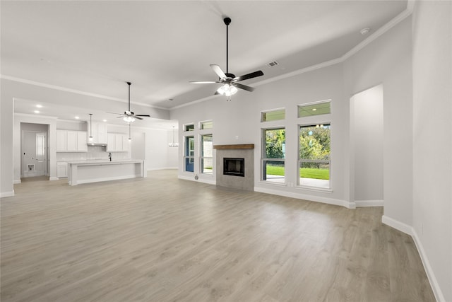 unfurnished living room featuring ornamental molding, baseboards, and a ceiling fan