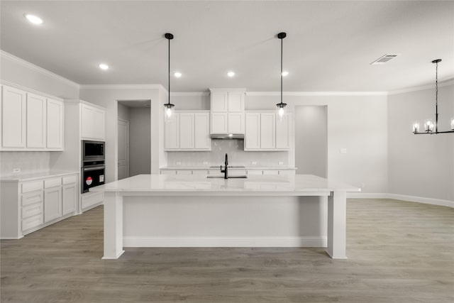 kitchen featuring built in microwave, visible vents, oven, and crown molding