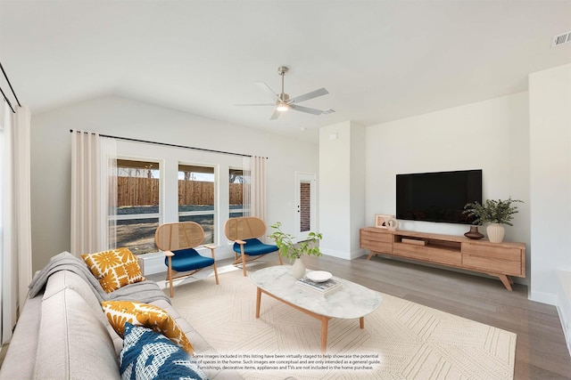 living area with a ceiling fan, visible vents, wood finished floors, lofted ceiling, and baseboards