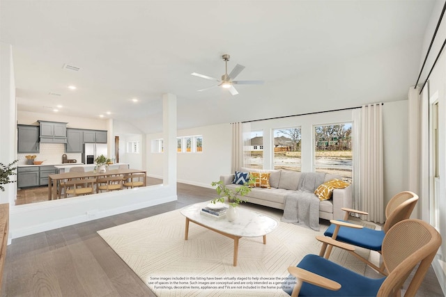 living area featuring baseboards, ceiling fan, recessed lighting, wood finished floors, and vaulted ceiling