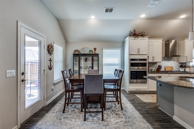 dining space with baseboards, lofted ceiling, dark wood-style flooring, and visible vents