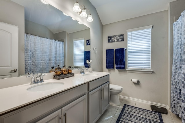 bathroom with toilet, vaulted ceiling, a sink, and tile patterned flooring