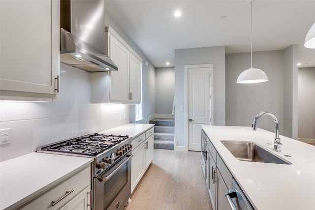 5707 Lindell Ave Unit 204, Dallas, TX 75206 - kitchen with light wood-type flooring, wall chimney range hood, appliances with stainless steel finishes, light countertops, and a sink