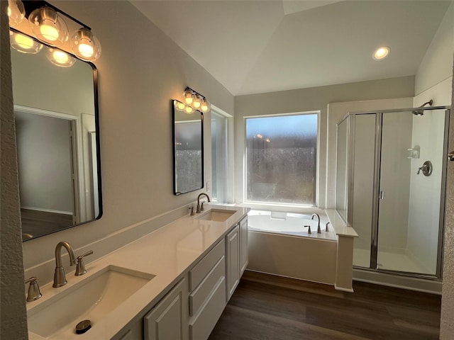 bathroom featuring a stall shower, wood finished floors, a sink, and a garden tub