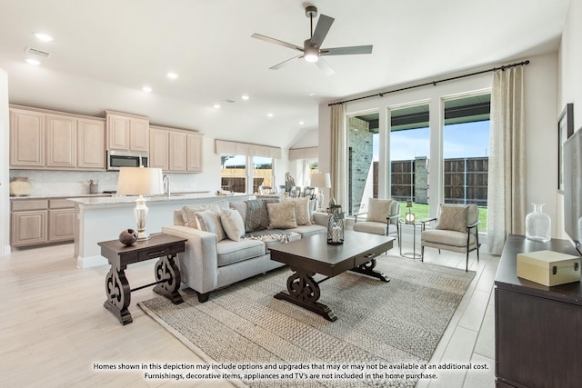 living room featuring light wood-type flooring, vaulted ceiling, recessed lighting, a ceiling fan, and visible vents