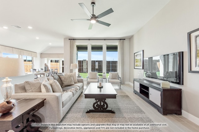 living area with light wood-type flooring, baseboards, a ceiling fan, visible vents, and lofted ceiling
