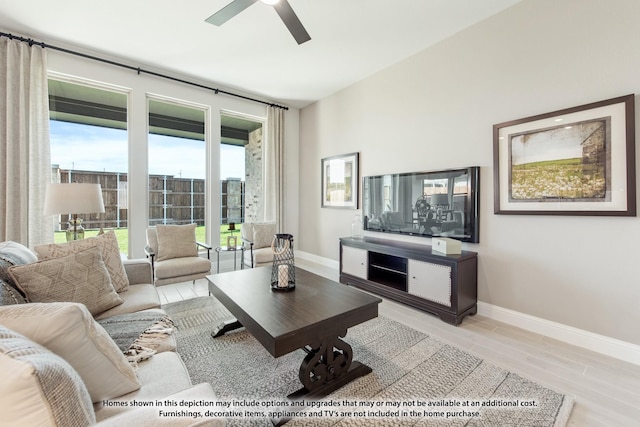 living room featuring light wood-style flooring, ceiling fan, and baseboards