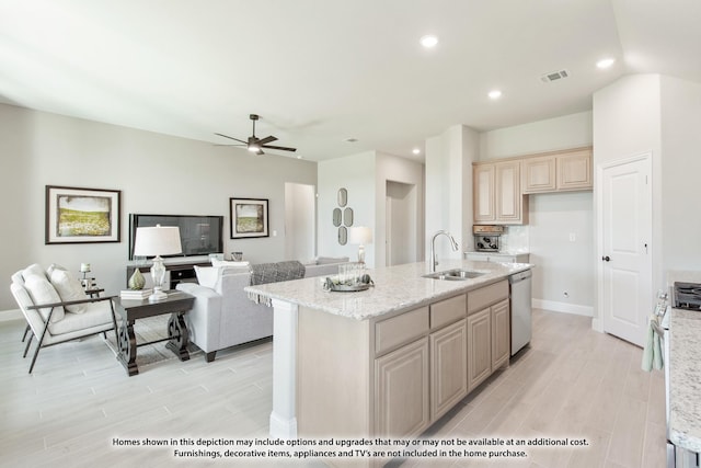 kitchen with light wood finished floors, open floor plan, dishwasher, and a sink