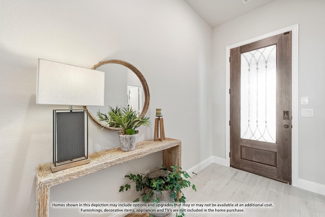 foyer with light wood-style flooring and baseboards
