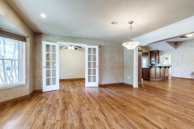 unfurnished dining area with light wood-type flooring, visible vents, a wealth of natural light, and french doors