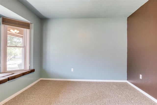 unfurnished room with carpet flooring and baseboards
