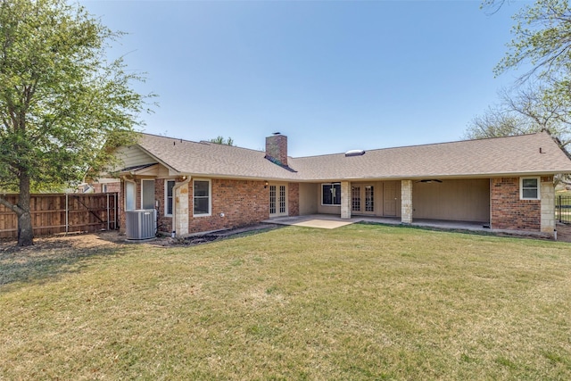 rear view of property featuring brick siding, fence, french doors, and a chimney