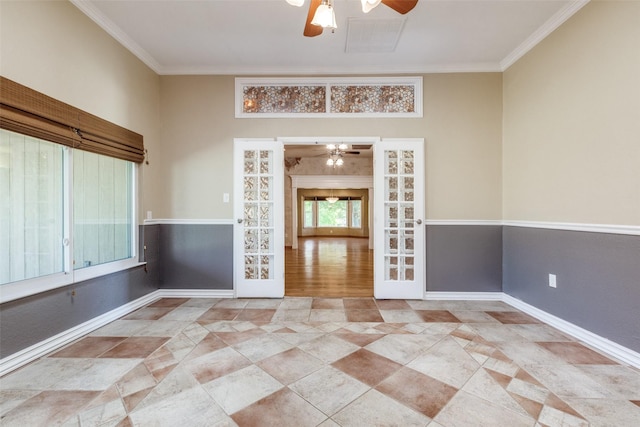 unfurnished room featuring baseboards, ornamental molding, ceiling fan, and french doors