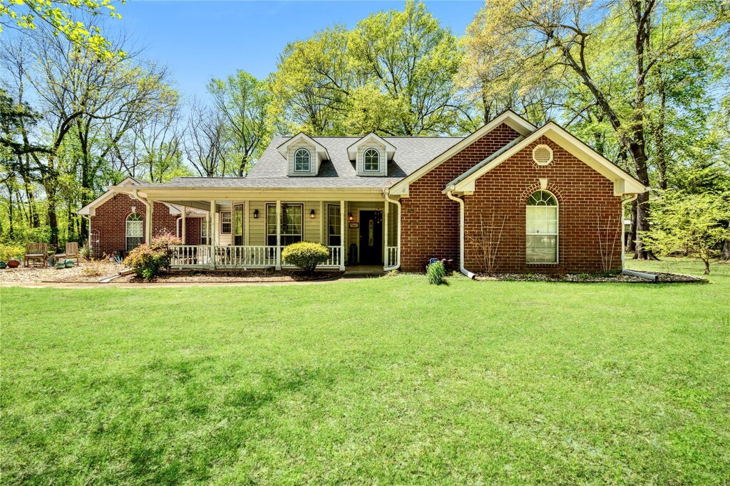 325 Timber Lakes Dr, Powderly, TX 75473 - view of front of house featuring a porch, a front lawn, and brick siding