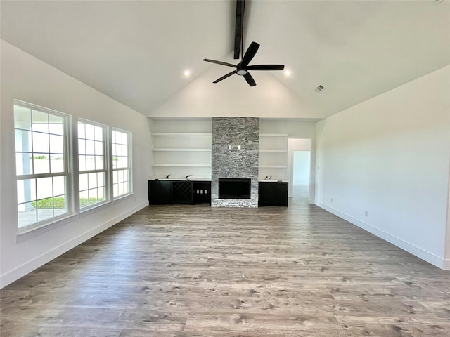 unfurnished living room with baseboards, built in features, beamed ceiling, a ceiling fan, and wood finished floors