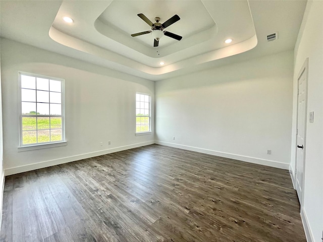 empty room featuring baseboards, ceiling fan, and a tray ceiling