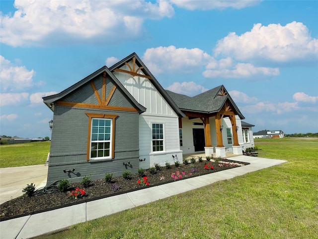 modern farmhouse style home with board and batten siding, brick siding, and a front lawn