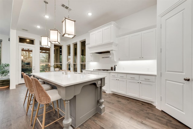 kitchen featuring light countertops, cooktop, white cabinets, and dark wood finished floors