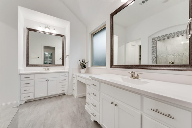full bathroom with baseboards, two vanities, a sink, and lofted ceiling