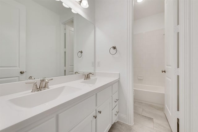full bath with double vanity, shower / washtub combination, and a sink