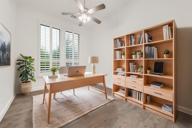 home office featuring crown molding, baseboards, a ceiling fan, and wood finished floors