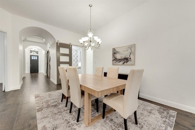 dining area featuring an inviting chandelier, arched walkways, baseboards, and wood finished floors
