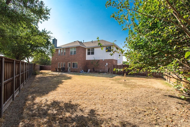 1314 Kingsley Ct, Allen, TX 75013 - rear view of property featuring brick siding, a fenced backyard, a lawn, and a patio area